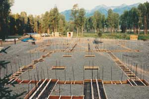 Precision cut footing system automatically squares itself