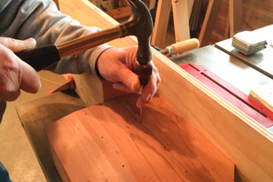 Enlarging the starter locations on both top and bottom of redwood base with a scratch awl
